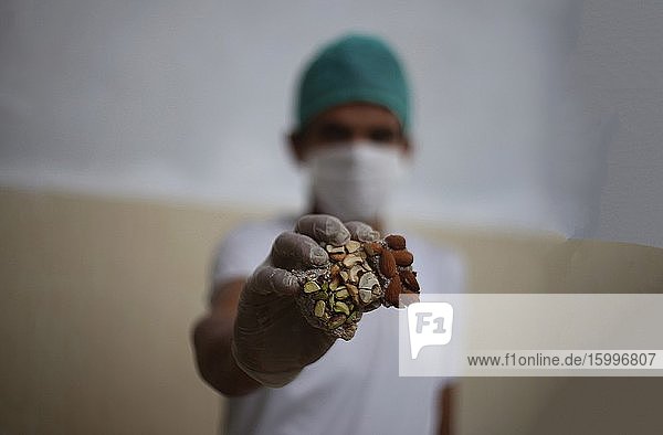 Palestinian workers wearing protective masks and hand gloves make Turkish sweets in a pastry factory in preparation for the upcoming Eid Al-Fitr holiday to mark the end of the holy month of Ramadan amid fears of the spread of the COVID-19 pandemic. May 18 2020.