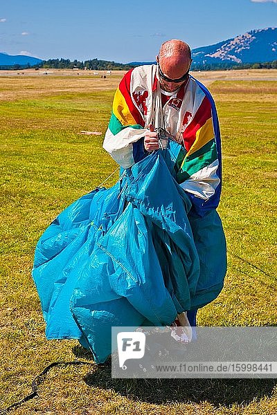 Parachutist gathering his chute after making a jump at an air show in Sidney British Columbia.