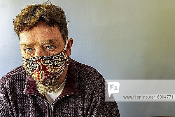 Tilburg  Niederlande. Selbstporträt / Selfie eines erwachsenen  kaukasischen Mannes  der eine handgefertigte Gesichtsmaske trägt  um den Corona-Vorschriften in öffentlichen Verkehrsmitteln zu entsprechen.