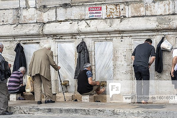 Men washing themselves at the cleaning fountain  washing ritual in front of the mosque  Yeni Cami  Fatih  Istanbul  Turkey  Asia
