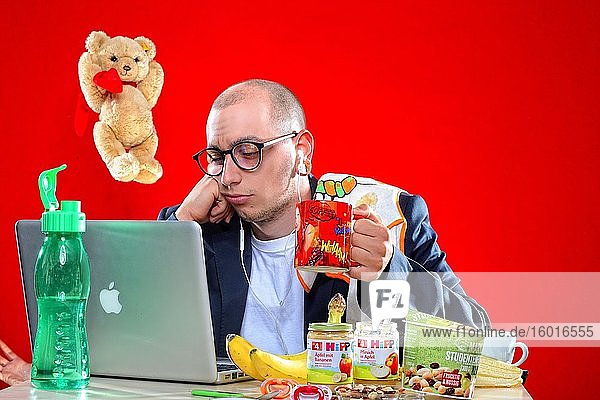 Young man with snacks in front of notebook Corona Series Germany Europe
