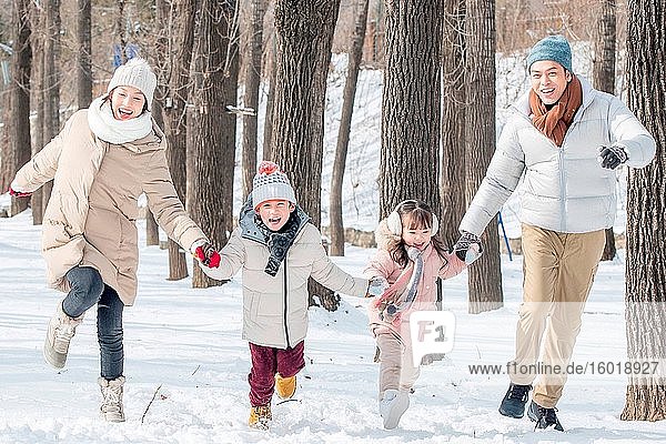 Happy family running in the snow