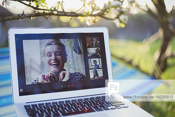 Video-Chat mit Freunden auf Laptop-Bildschirm im sonnigen Garten