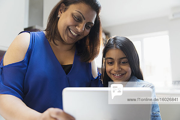 Glückliche Mutter und Tochter mit digitalem Tablett