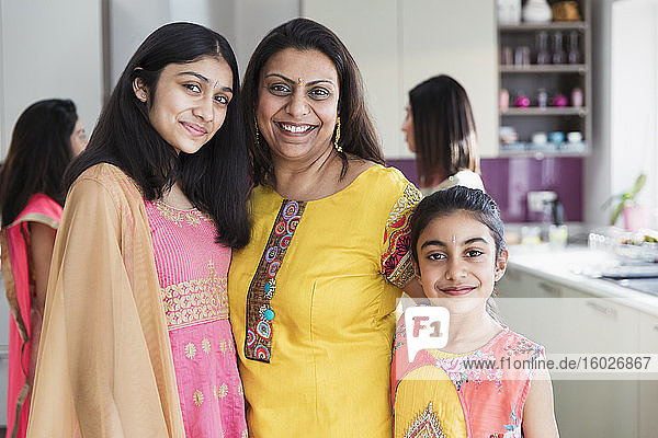 Portrait happy Indian mother and daughters in saris