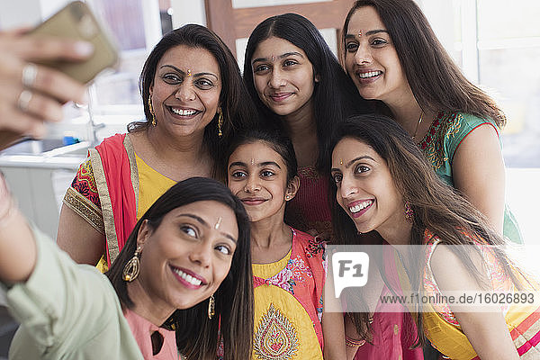 Glückliche indische Frauen und Mädchen in Saris bei der Selbsthilfe