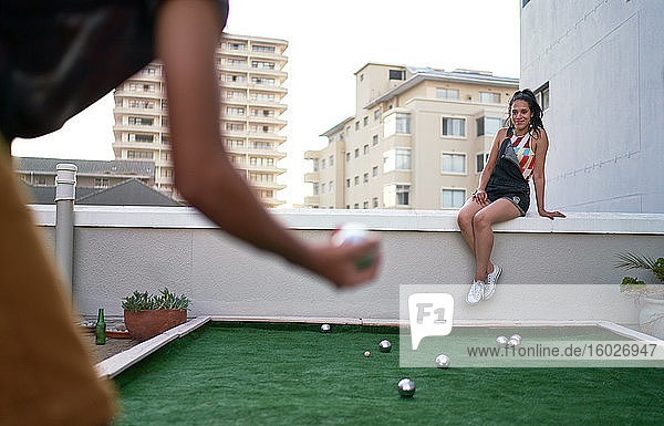 Junges Paar spielt Bocciaball auf dem Dach einer Stadt