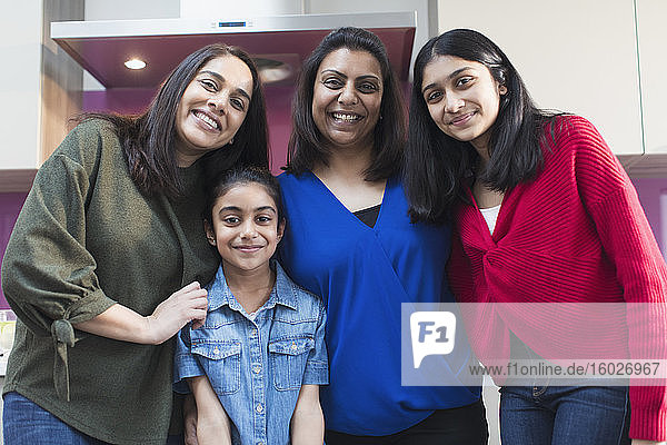 Porträt glücklicher indischer Mütter und Töchter in der Küche
