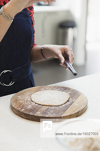 Frau macht Naan-Brot in der Küche