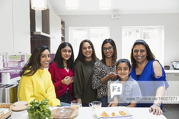 Porträt glücklicher indischer Frauen und Mädchen beim Kochen in der Küche