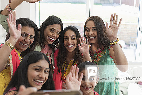Fröhliche indische Frauen und Mädchen in Saris und Bindis beim Selbstausstieg