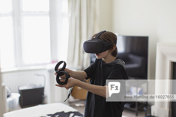 Junge spielt Videospiel mit VRS-Brille im Wohnzimmer