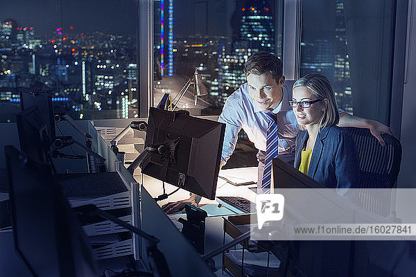 Business people working late at computer in office
