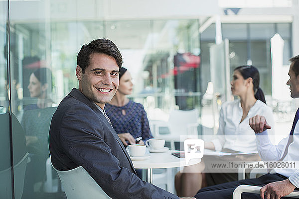Lächelnder Geschäftsmann bei Treffen im Straßencafé