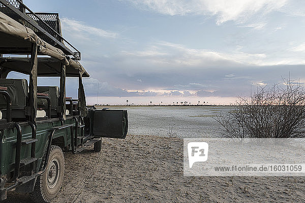 Safarifahrzeug mit Blick über die Salzpfannenlandschaft Kalahari-Wüste.
