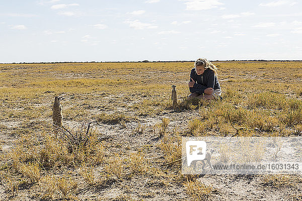 12 year old girl looking at Meerkats  Kalahari Desert