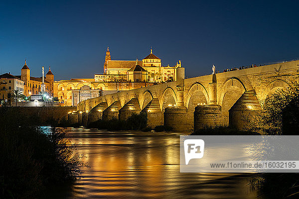 The Roman Bridge (Puente Romano) and The Great Mosque of Cordoba lit up during evening twilight at dusk  UNESCO World Heritage Site  Cordoba  Andalusia  Spain  Europe