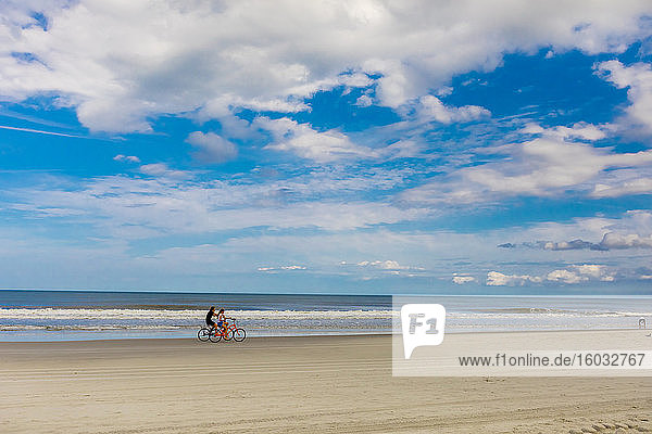 Couple bike riding on Jacksonville beach after it reopened during the Covid-19 Pandemic  Florida  United States of America  North America