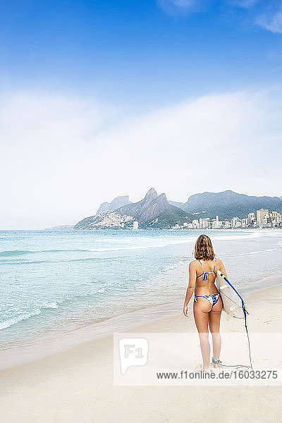 An athletic woman surfer in a bikini on Ipanema beach  Rio de Janeiro  Brazil  South America