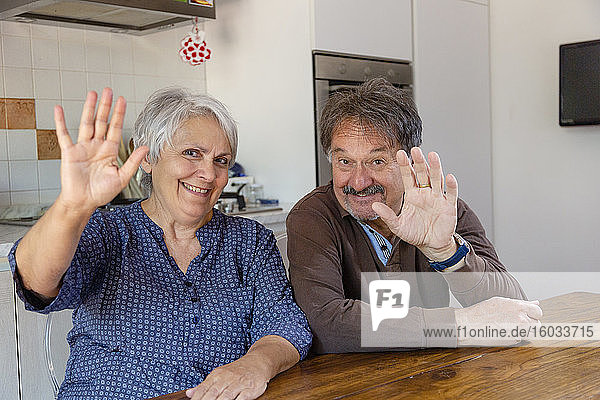 Älterer Mann und Frau winken vor der Kamera  Online-Feier während der Sperrung des Coronavirus.