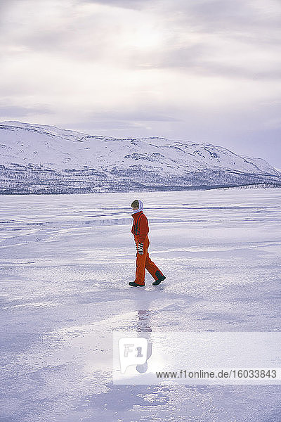 Boy standing on frozen lake in Vasterbottens Lan  Sweden.
