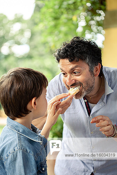 Junge und Vater essen Brot
