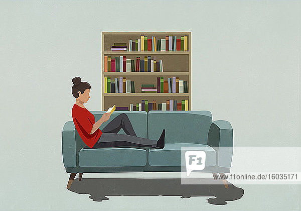 Frau liest Buch auf dem Sofa