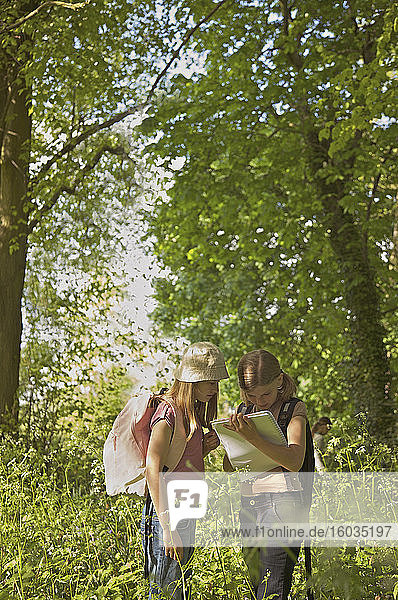 Mädchen mit Notizbuch auf Exkursion im Wald