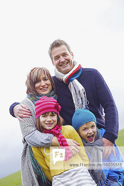 Porträt einer glücklichen Familie mit Hüten und Schals