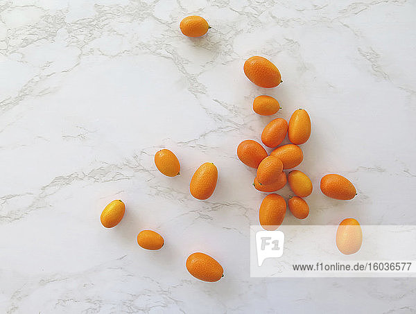 Kumquats auf weißem Marmoruntergrund