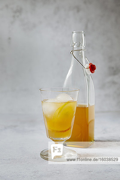 Earl Grey Tee mit Apfelscheiben und Eiswürfeln in Glas und Flasche