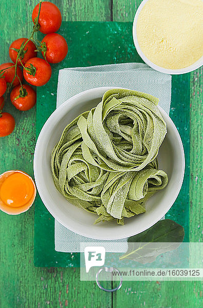 Fresh green tagliatelle with tomatoes,  egg and flour