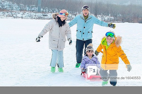 Spielen mit Schneerutsche eine vierköpfige Familie