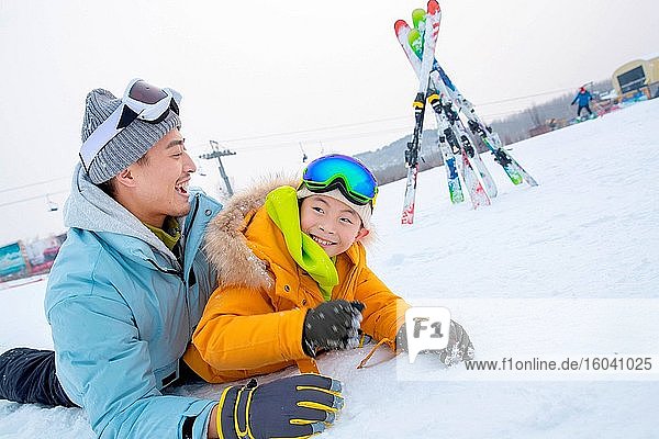 Skiing field in rolling happy father and son together