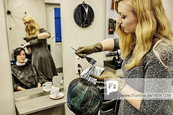 Hairdresser in a hairdressing salon dying strands of hair with aluminium foil  Cologne  North Rhine-Westphalia  Germany  Europe
