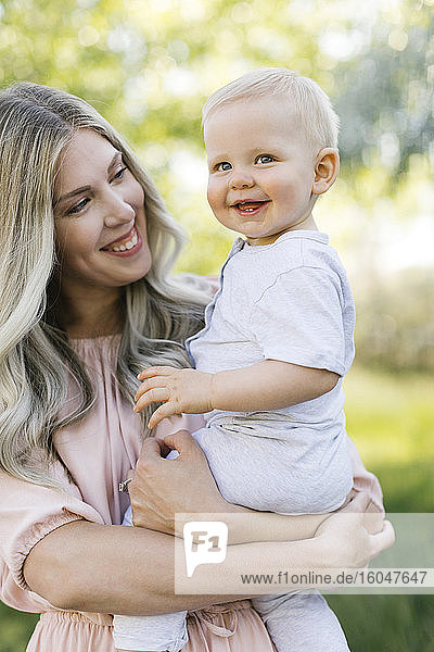 Outdoor portrait of smiling mother and baby son