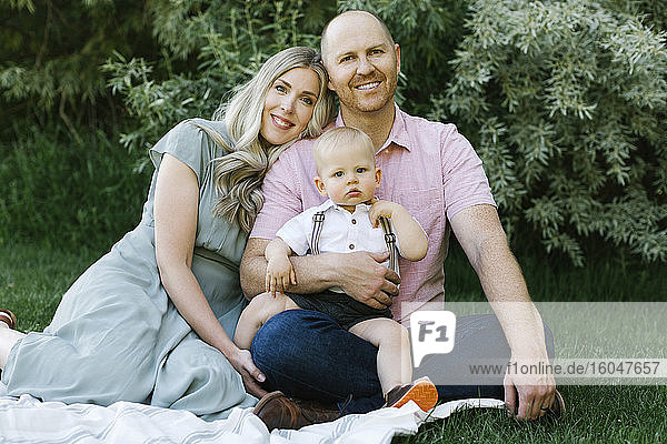 Outdoor portrait of happy parents with baby son