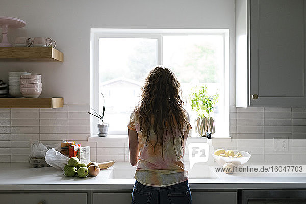Frau wäscht Obst und Gemüse in der Küche