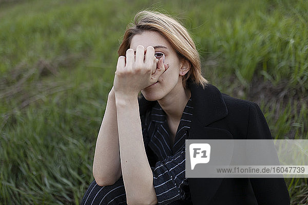 Russland  Omsk  Porträt einer jungen Frau  die im Gras sitzt