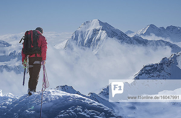 Italien  Alpen  Bergsteiger mit Blick auf verschneite Berglandschaft