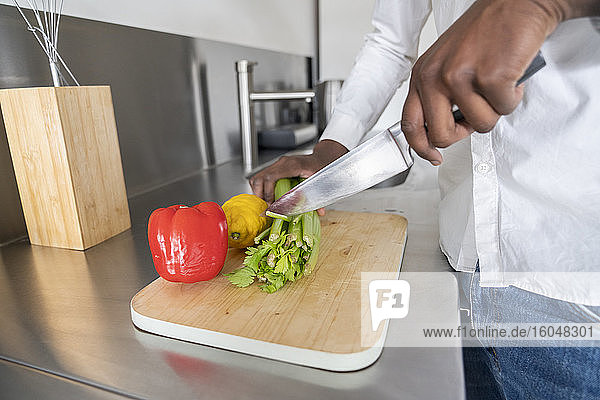 Crop view of man cutting celery on kitchen counter  close-up