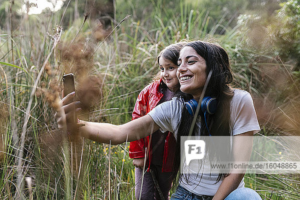 Mutter und Tochter machen ein Selfie im Wald