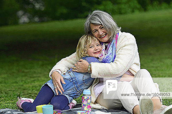 Zärtliche Umarmung zwischen Großmutter und Enkelin in einem öffentlichen Park