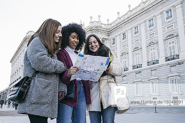 Weibliche Touristen analysieren eine Landkarte  während sie vor dem Königspalast in Madrid stehen  Spanien