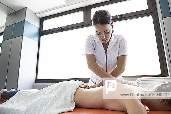 Female physiotherapist massaging the back of a woman