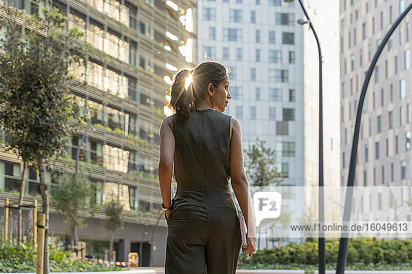 Frau schaut weg  während sie in einer modernen Stadt spazieren geht