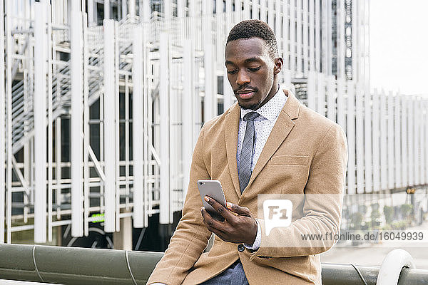 Young businessman using smartphone in the city