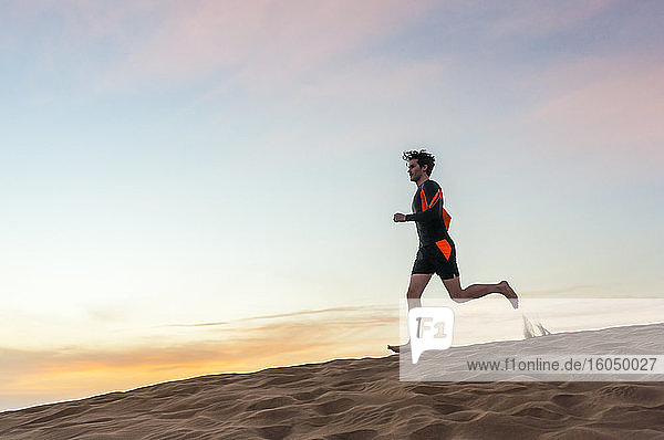Man running at sunset in the dunes  Gran Canaria  Spain