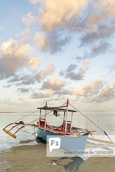 Philippinen  Siargao  General Luna  Fischerboot am Strand bei Sonnenuntergang