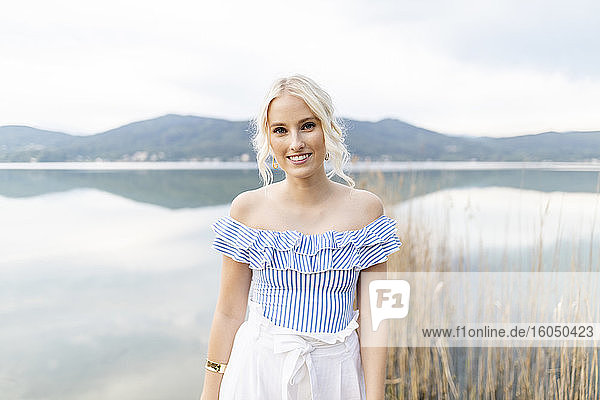 Portrait of fashionable blond woman standing in front of Woerthersee  Austria